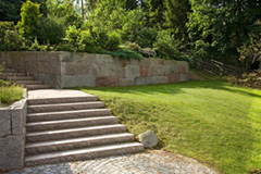 Flerfärgad stenmur och trappa i granit