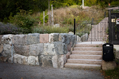 Stenmur i natursten och stentrappa i granit